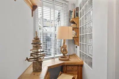 a room with a table with a lamp and a window at Cosy Fisherman's Cottage Seconds from Waterfront in St Ives