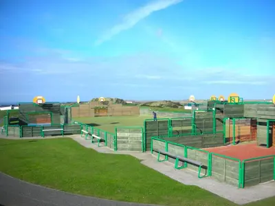 a baseball field with benches in the grass at Chalet 150, Perran Sands in Perranporth