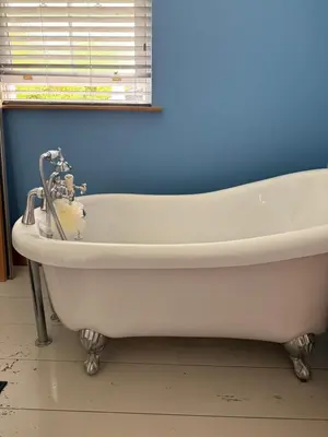 a white bath tub in a bathroom with a window at Buddleia Cottage Trewoon, St Austell in St Austell