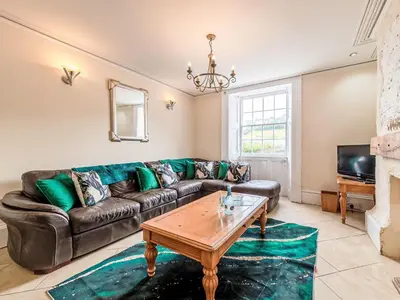 a living room with a leather couch and a coffee table at Holiday Home Tregony House 1 Bedroom by Interhome in Mevagissey