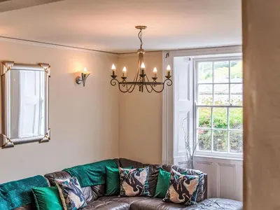 a living room with a couch and a window at Holiday Home Tregony House 2 Bedrooms by Interhome in Mevagissey