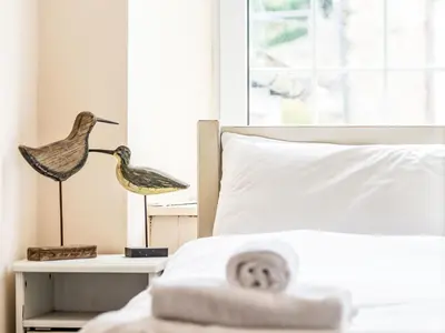 a bedroom with a bed with a bird statue on a table at Holiday Home Tregony House 2 Bedrooms by Interhome in Mevagissey