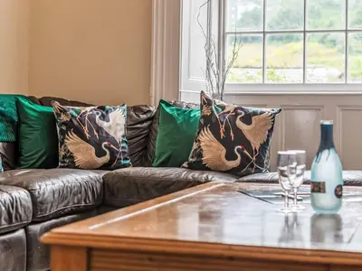 a living room with a leather couch and a table at Holiday Home Tregony House 2 Bedrooms by Interhome in Mevagissey