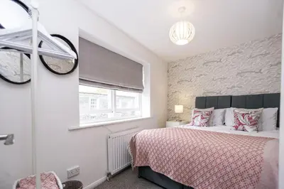 a bedroom with a bed and a window at St Ives Holiday Cottage with Parking – Coastal Retreat in St Ives