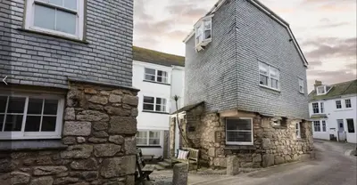 an old stone house with a gray roof at St Ives Holiday Cottage with Parking – Coastal Retreat in St Ives