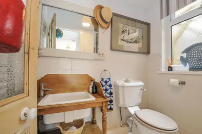 a bathroom with a toilet and a sink at Mayhurst in Looe
