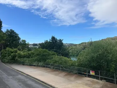 a bridge over a river next to a road at Mayhurst in Looe