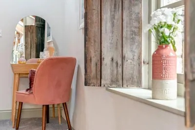 a chair in a room with a mirror and a vase at 1 Bed in Newquay oc-c33290 in Saint Columb Major