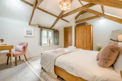a bedroom with a large bed and a desk at 1 Bed in Newquay oc-c33290 in Saint Columb Major