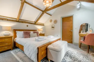 a bedroom with a large bed and a chair at 1 Bed in Newquay oc-c33290 in Saint Columb Major