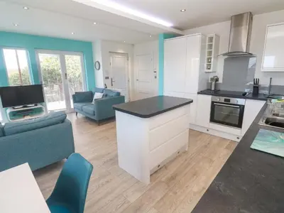a kitchen and living room with a couch and a table at Lodge 83, Gwel an Mor in Redruth