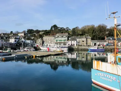 a boat is docked in a marina with houses at Cozy Retreat in Padstow