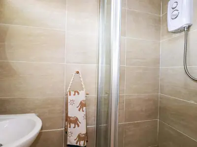 a bathroom with a shower with a toilet and a towel at Cozy Retreat in Padstow