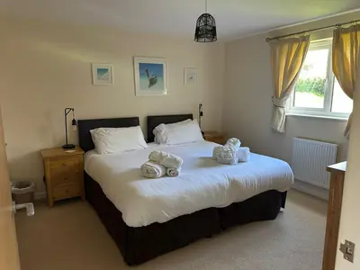 a bedroom with a large bed with towels on it at Redwood at Retallack Resort in Saint Columb Major