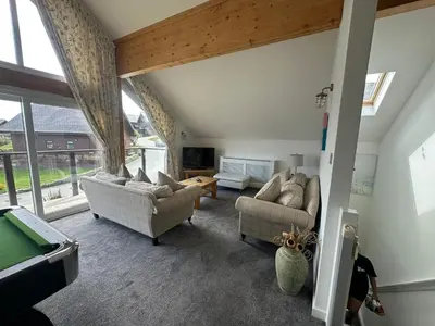 a living room with two couches and a large window at Redwood at Retallack Resort in Saint Columb Major