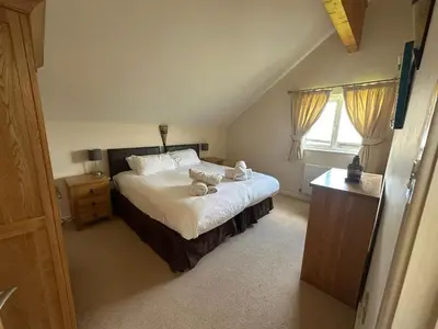 a bedroom with a bed with two teddy bears on it at Redwood at Retallack Resort in Saint Columb Major