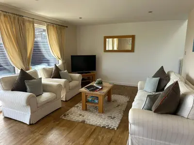a living room with two couches and a tv at Redwood at Retallack Resort in Saint Columb Major