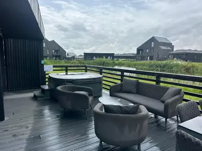a deck with couches and a table and chairs at Barn 21 at Retallack Resort in Saint Columb Major