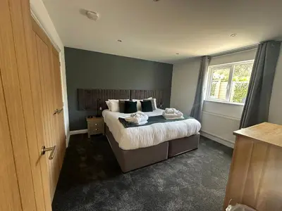 a bedroom with a bed and a window at Willow at Retallack Resort in Saint Columb Major