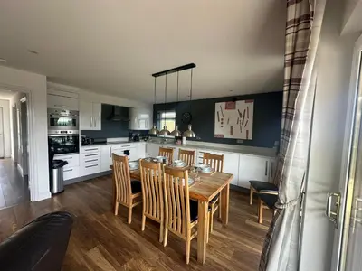 a kitchen and dining room with a table and chairs at Willow at Retallack Resort in Saint Columb Major