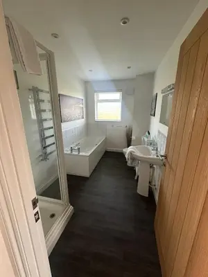 a bathroom with a tub and a sink and a bath tub at Willow at Retallack Resort in Saint Columb Major