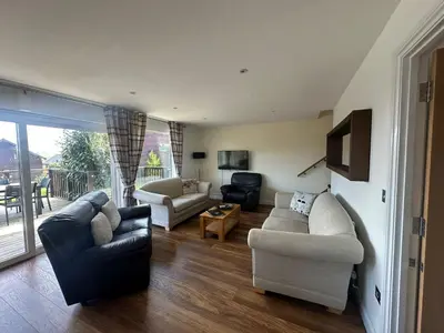 a living room with two couches and a tv at Willow at Retallack Resort in Saint Columb Major