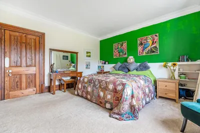 a bedroom with green walls and a bed and a desk at The Old Vicarage in Truro