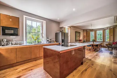 a large kitchen with a large island in the middle at The Old Vicarage in Truro