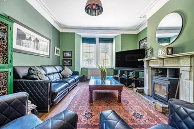 a living room with a couch and a tv at The Old Vicarage in Truro