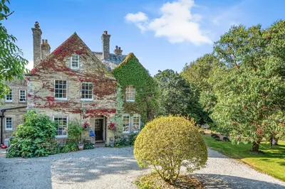 an old stone house with a garden in front of it at The Old Vicarage in Truro