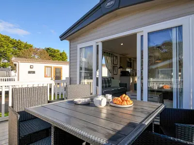a wooden table with a plate of food on a patio at Eden Way 47 in Par