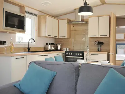 a kitchen with a table and blue chairs in a kitchen at Eden Way 47 in Par