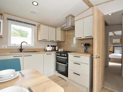 a kitchen with white cabinets and a black stove at Eden Way 47 in Par