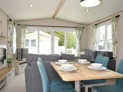 a dining room with a table and blue chairs at Eden Way 47 in Par