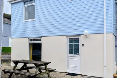 a house with a picnic table in front of it at Atlantic Lodge - 4 Bedroom - Pool -Spa - Gym in Newquay