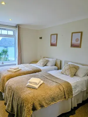 two beds in a bedroom with towels on them at Atlantic Lodge - 4 Bedroom - Pool -Spa - Gym in Newquay