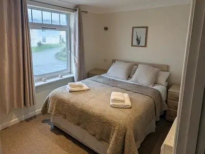 a bedroom with a bed with two towels on it at Atlantic Lodge - 4 Bedroom - Pool -Spa - Gym in Newquay