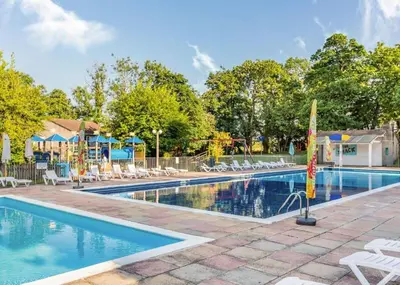a swimming pool with chairs and a playground at Atlantic Lodge - 4 Bedroom - Pool -Spa - Gym in Newquay