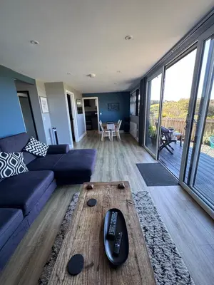 a living room with a remote control on a coffee table at The Lodge in Perranporth