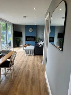 a living room with a bed and a dining room at The Lodge in Perranporth