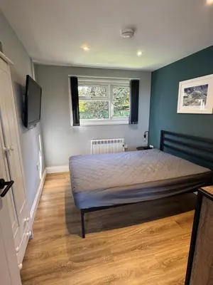 a bedroom with a bed and a television in it at The Lodge in Perranporth