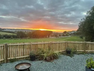 a wooden fence with a table and a chair at The Lodge in Perranporth