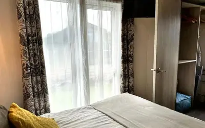 a bedroom with a window and a bed in front of it at Vyvyenne Lodge in Padstow