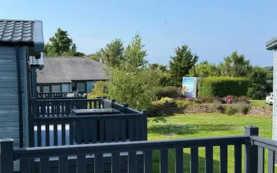 a house with a black fence and a yard at Vyvyenne Lodge in Padstow