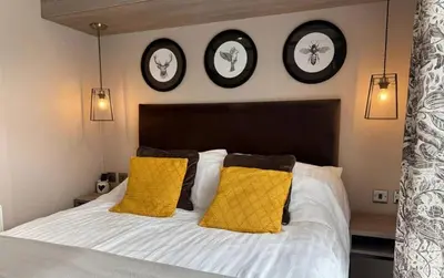 a bedroom with a bed with three clocks on the wall at Vyvyenne Lodge in Padstow