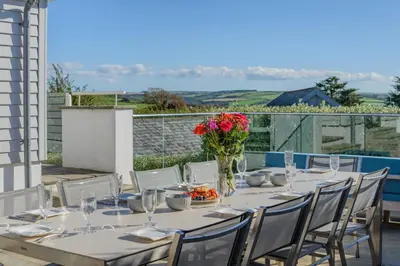 a long table with a vase of flowers and chairs at 5 Bed in Rock oc-m33185 in Roche