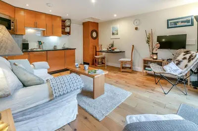 a living room with a couch and a kitchen at 1 Bed in Fowey oc-p33360 in Fowey