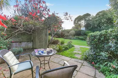 a patio with chairs and a table in a garden at 1 Bed in Fowey oc-p33360 in Fowey