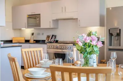 a kitchen with a table with a vase of flowers on it at 3 Bed in Fowey oc-o33078 in Fowey