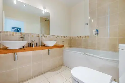 a bathroom with two sinks and a tub and a toilet at 3 Bed in Fowey oc-o33078 in Fowey